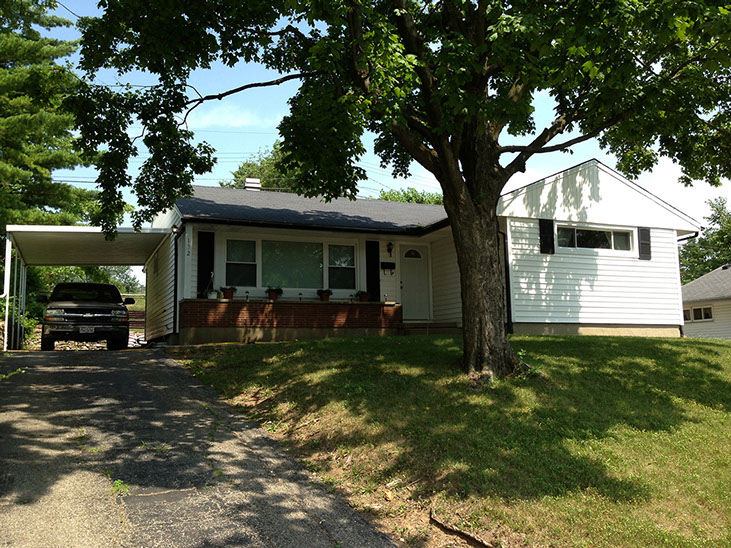 uphill driveway, attached car port, brick
