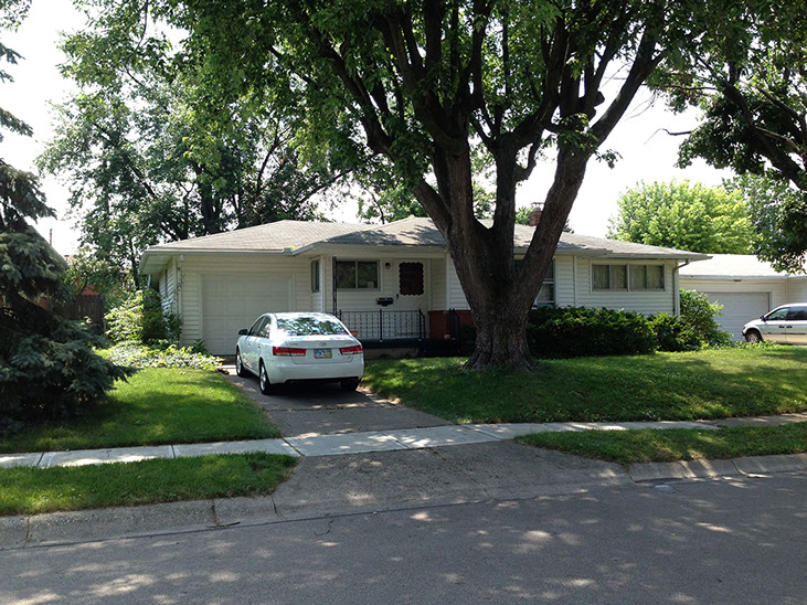 large front tree, driveway, attached garage